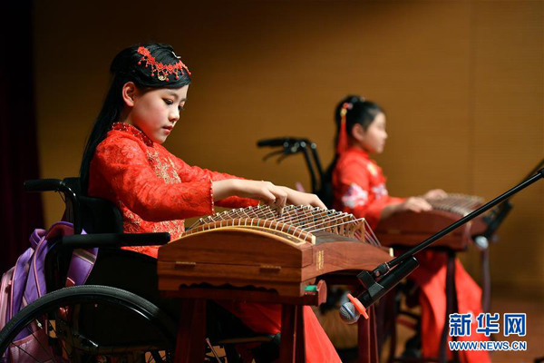 1月24日，青少年残健融合班学员武姗姗（左）在表演古筝弹奏《渔舟唱晚》。