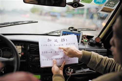 莫教练用写字以及打手势的方式指导听障学生练车。