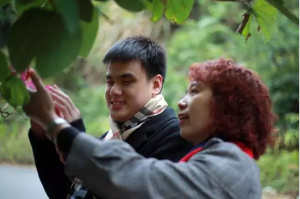 母亲带王子安（左一）通过触摸感知植物